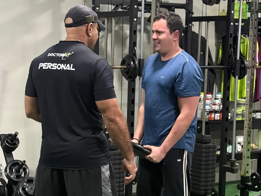 Personal da DoctorFit conversando com aluno sobre o treino do dia